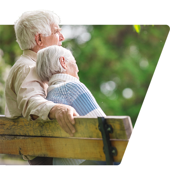 elderly couple sitting on a park bench