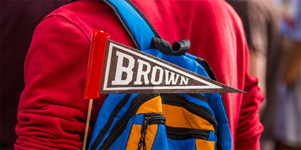A student with a Brown pennant on their backpack