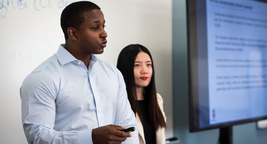 Several people shown on a monitor in a virtual classroom