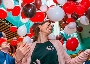 Match Day celebration - woman smiling with balloons in background