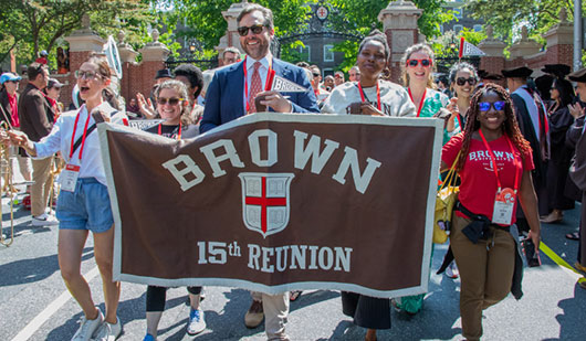 15th reunion class members marching in procession with 15th Reunion banner