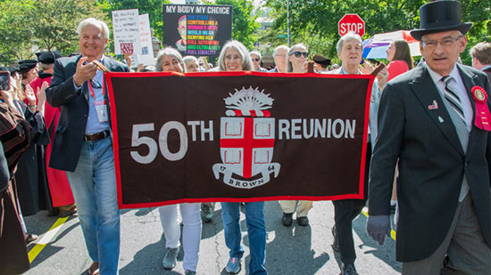 50th reunion class members marching in procession with 50th Reunion banner