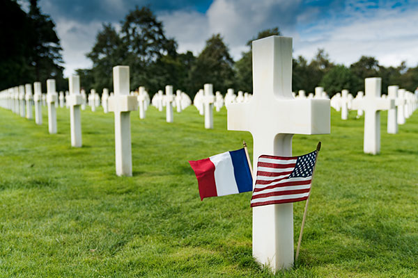 French flag and American flag at gravesite in cemetery