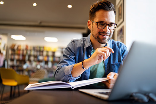 Person studying with laptop at the library