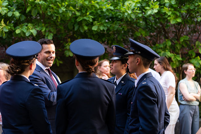 Alex Wagner '99 speaking with a group of officers