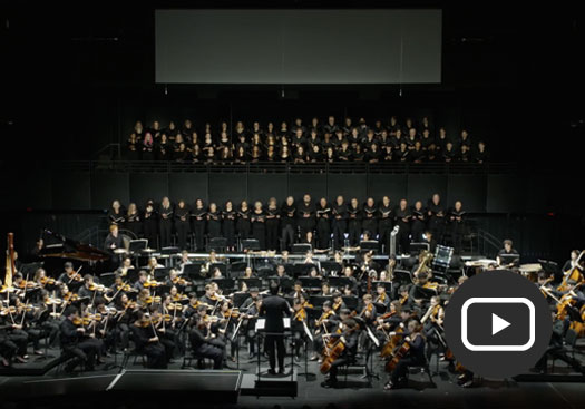 screenshot of orchestra and chorus performance with play icon